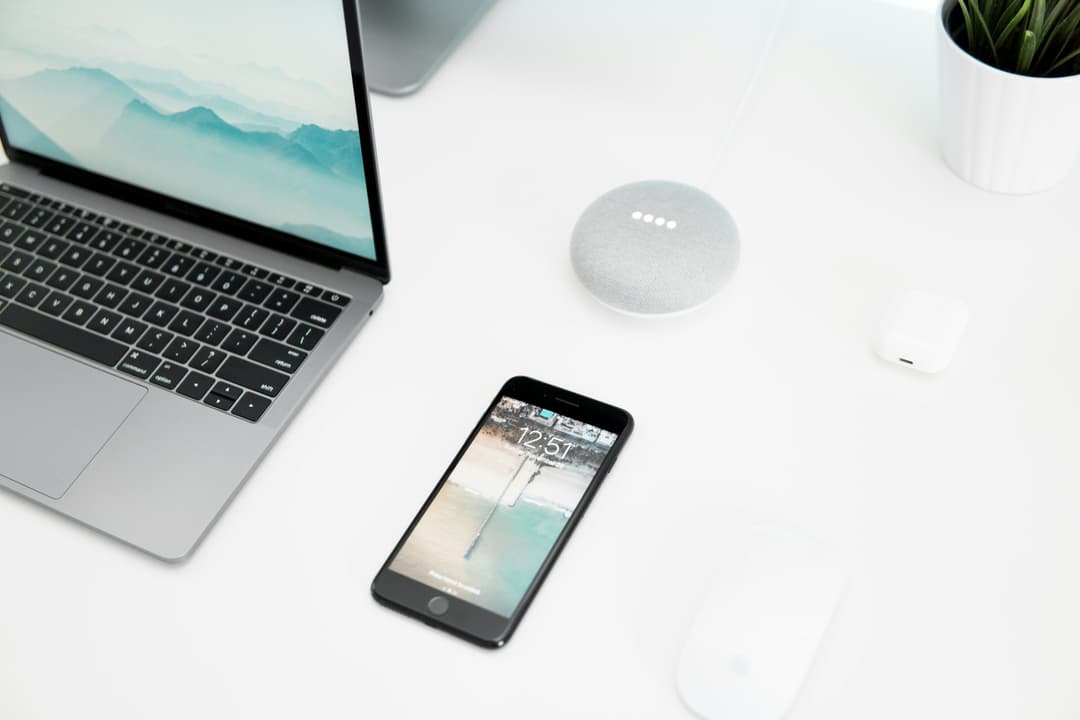 Phone and laptop kept on a white desk